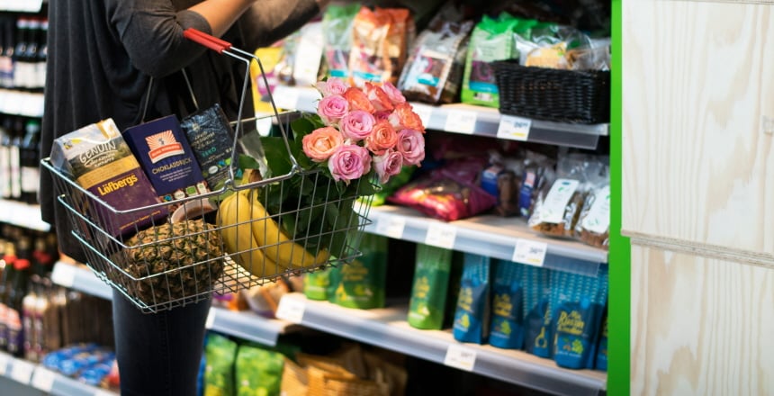 Kvinna i butik med fair trade-varor i varukorg